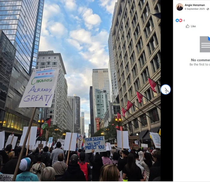 A crowd fills a downtown Chicago street between tall buildings, holding protest placards. Visible signs include messages about Chicago and silence, with Palestinian flags visible above the crowd.