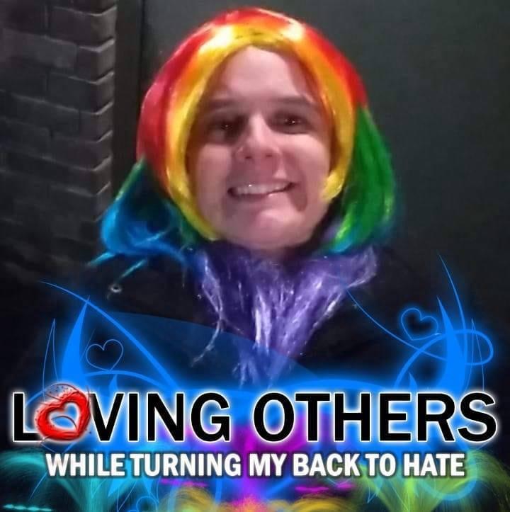A supplied portrait with a rainbow-colored wig and a graphic reading LOVING OTHERS WHILE TURNING MY BACK TO HATE.