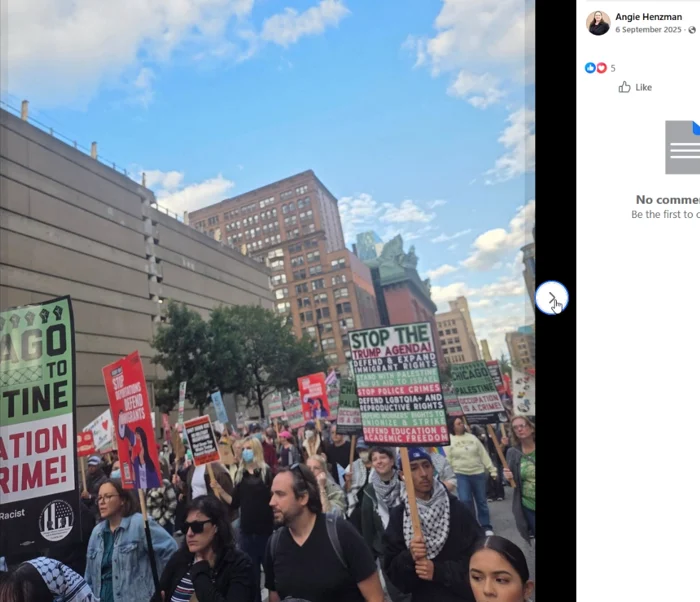 Facebook screenshot of a street crowd carrying protest placards beneath a blue sky, with downtown buildings in the background. A central placard calls to stop the Trump agenda and defend immigrant rights.